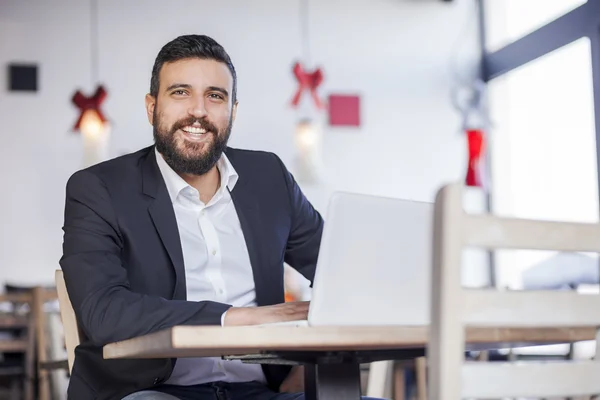 Businessman working on laptop in restaurant — Stock Photo, Image