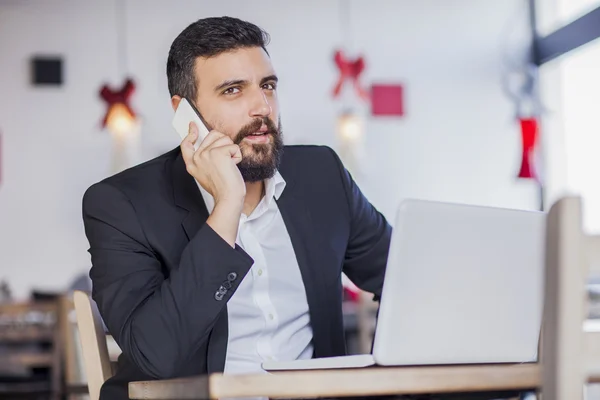 Businessman talking on phone in restaurant — Stock Photo, Image