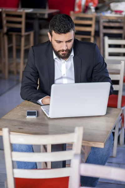Hombre de negocios trabajando en el ordenador portátil en el restaurante — Foto de Stock