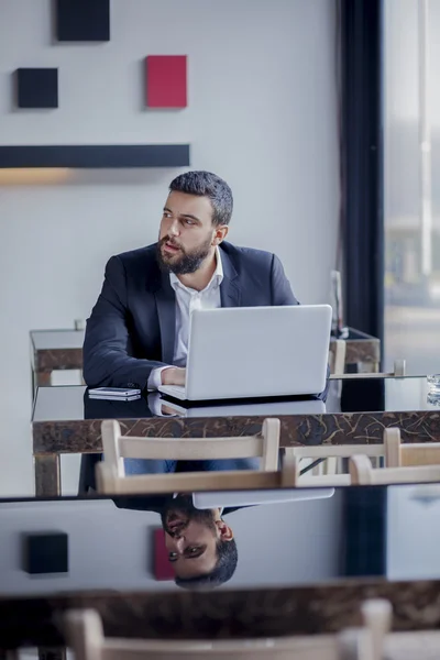 Zakenman die op laptop in restaurant werkt — Stockfoto