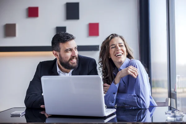 Geschäftsfrau und Geschäftsmann arbeiten am Laptop — Stockfoto