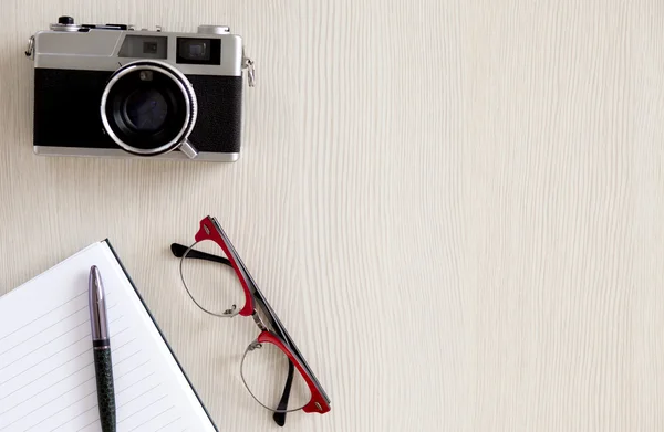 Ноутбук, ручка, очки и старая камера — стоковое фото