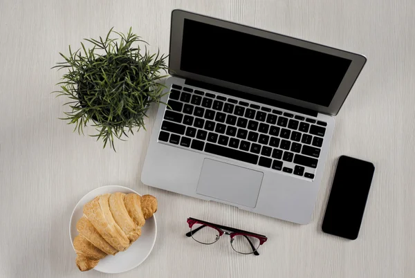 Laptop, smartphone, gafas y croissant — Foto de Stock