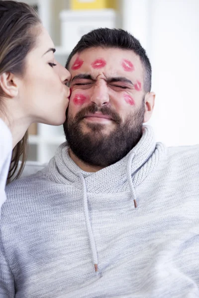 Frau küsst Mann mit rotem Lippenstift — Stockfoto