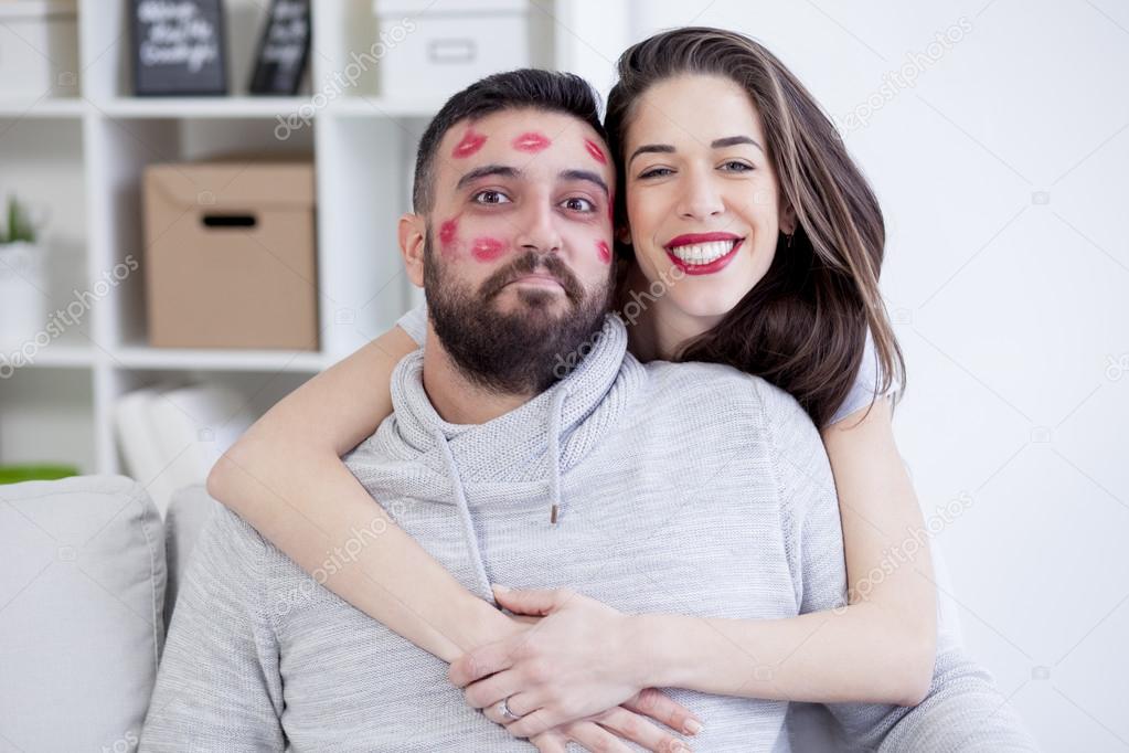 Woman kissing man with red lipstick