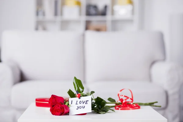 Röda rosor med anteckning jag älskar dig — Stockfoto