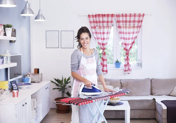 Ama de casa plancha lavandería en la habitación — Foto de Stock