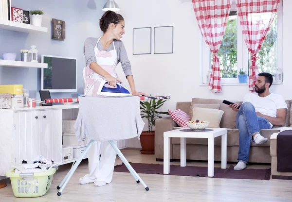 Frau bügelt Wäsche im Zimmer — Stockfoto