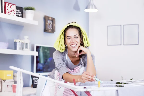 Mujer extendiendo la ropa en la habitación — Foto de Stock