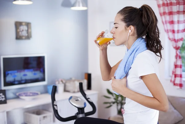 Mujer bebiendo jugo mientras entrena — Foto de Stock