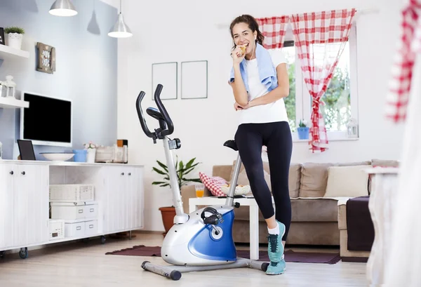 Mujer comiendo manzana mientras entrena en casa —  Fotos de Stock