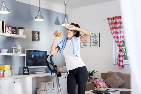 Mujer bebiendo mientras entrena en casa — Foto de Stock