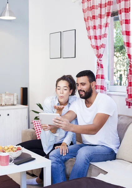 Pareja usando tableta en sofá —  Fotos de Stock