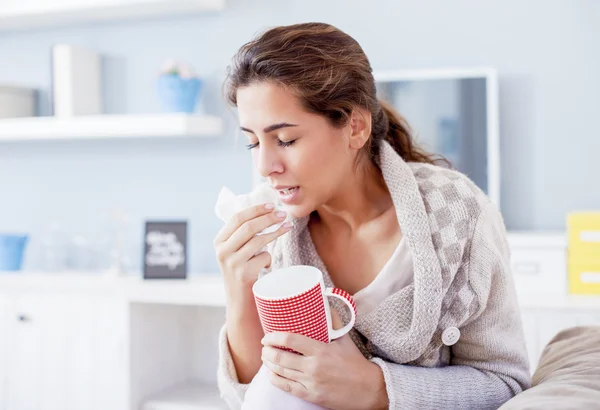 Mujer enferma sonándose la nariz y bebiendo té — Foto de Stock