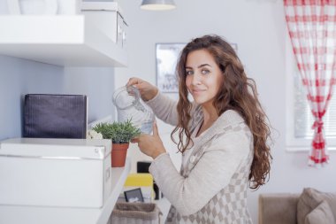 Çiçek düzenliyor ve onun oturma odası dekorasyon güzel kadın