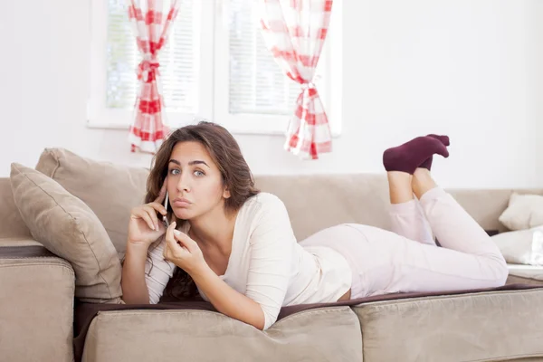 電話で話しているソファの上の女性 — ストック写真