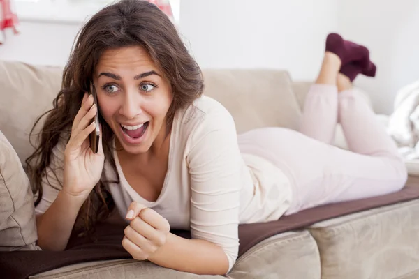 Nő a kanapé beszél telefonon — Stock Fotó