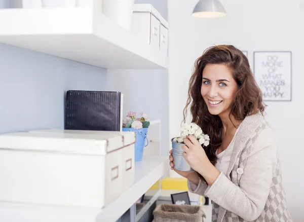 Mujer hermosa arreglando flores y decorando su sala de estar — Foto de Stock