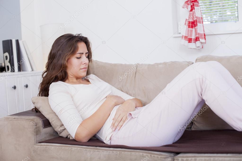woman on bed with stomach pain
