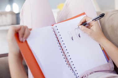 Rahat yatağında oturmuş ve notlar günlüğünü, sığ derinliği için yapım genç ve güzel kadın şikayetçi