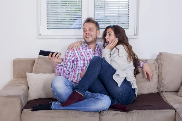 Atractiva pareja abrazándose en el sofá en casa en la sala de estar — Foto de Stock