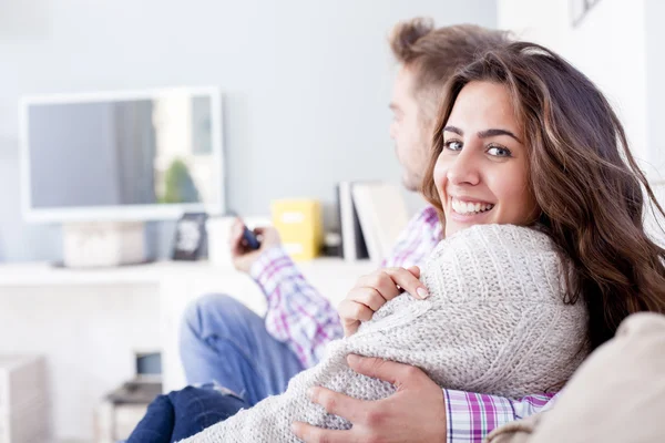 Привлекательная пара обнимается на диване дома в гостиной — стоковое фото