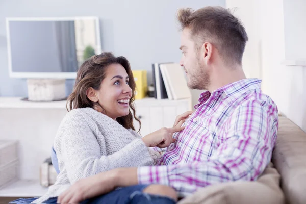 Aantrekkelijke paar knuffelen op de Bank thuis in de woonkamer — Stockfoto