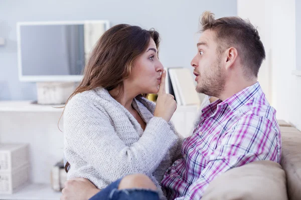Attractive couple cuddling on the couch at home in the living room — Stock Photo, Image