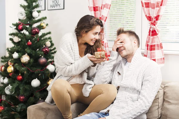 Couple échangeant des cadeaux par sapin de Noël. Couple heureux dans Santa — Photo