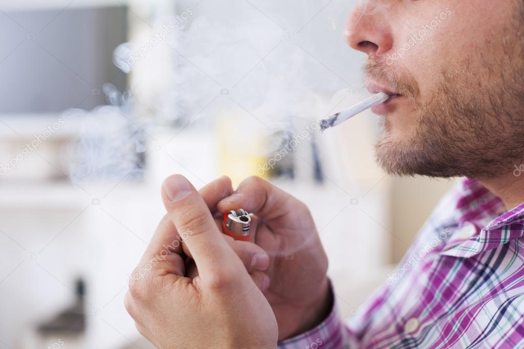 Close up of Man smoking cigarette. Man lighting the cigarette.