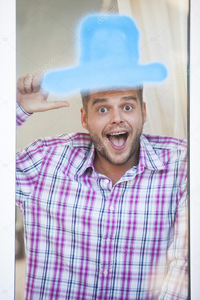 Man at window with blue drawn hat. Funny picture 