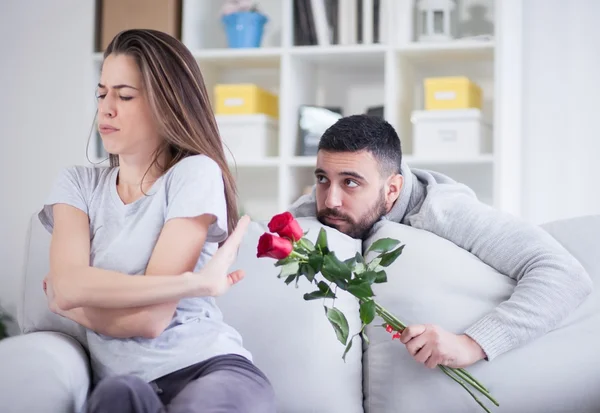Man gives flower to angry girlfriend — Stock Photo, Image