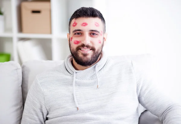 Man with red kisses marks on  face