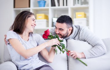 genç adam bir kırmızı gül kız arkadaşına veriyor