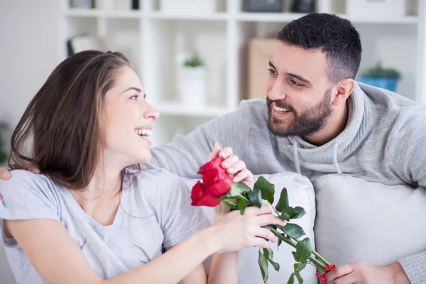 Jeune homme donnant une rose rouge à sa petite amie — Photo