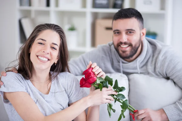 Junger Mann schenkt seiner Freundin eine rote Rose — Stockfoto