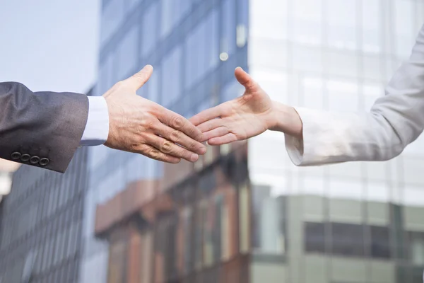 Empresária e empresário apertando as mãos — Fotografia de Stock