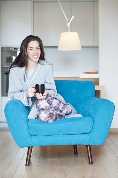 Mujer en sofá sosteniendo café — Foto de Stock