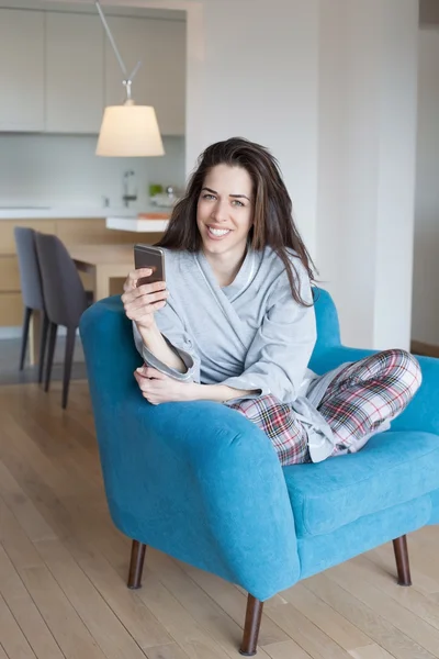 Жінка в дивані і за допомогою телефону — стокове фото