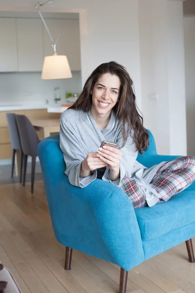 Vrouw op de Bank met behulp van telefoon — Stockfoto