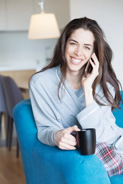 Vrouw op bank praten over telefoon — Stockfoto