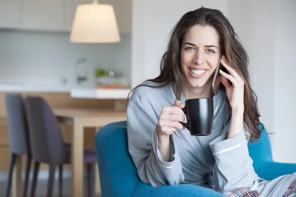 Mujer en el sofá hablando por teléfono —  Fotos de Stock