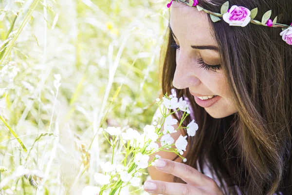 Kvinna i äng att lukta blommor — Stockfoto