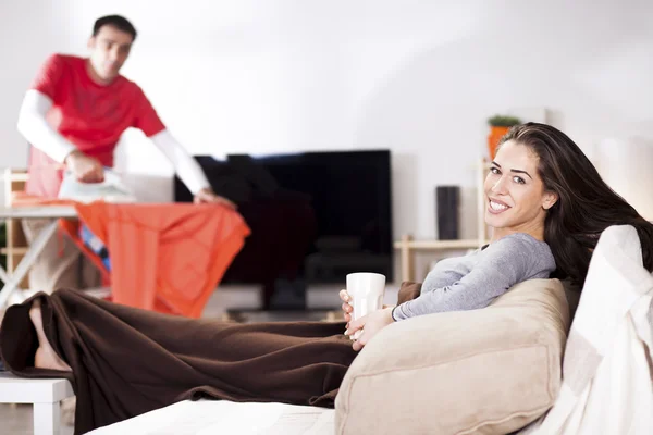 Mulher sentada no sofá assistindo TV — Fotografia de Stock