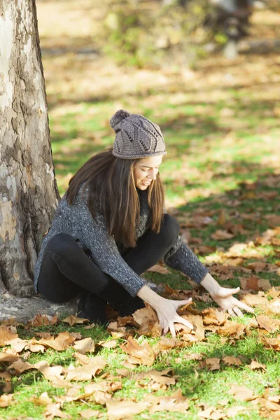 Brunetta donna giocare con foglie — Foto Stock
