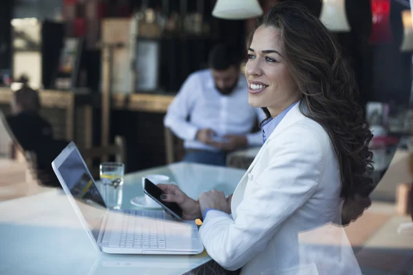 Fiatal üzletasszony caffe dolgozik laptop ablak mellé ül — Stock Fotó