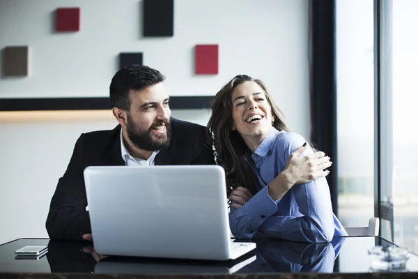 Sonriente atractiva mujer de negocios y hombre de negocios que trabajan en el ordenador portátil juntos —  Fotos de Stock