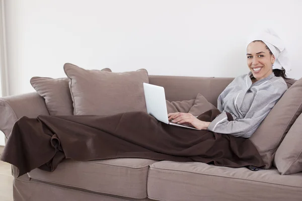 Kadın kanepede yatan ve oturma odasındaki laptop çalışma — Stok fotoğraf