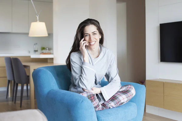 Vrouw zitten in de Bank in de woonkamer. Ochtend scène, vrouw die lacht — Stockfoto