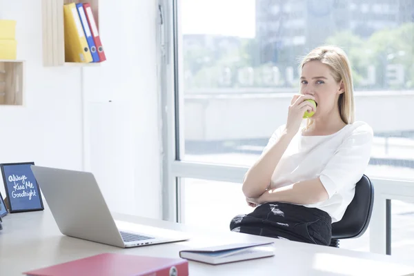 Business woman having healthy snack, eating apple — Stock Photo, Image